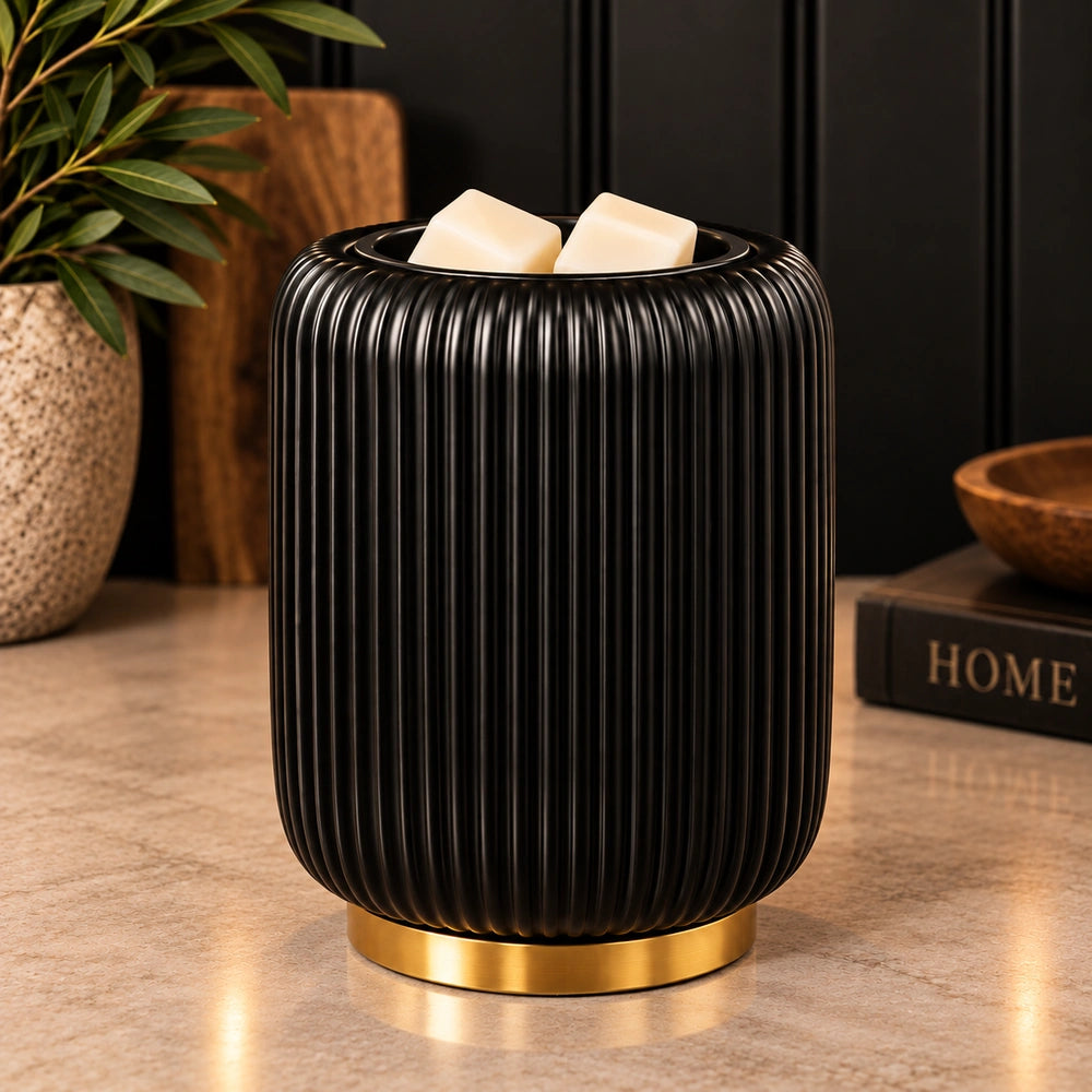 Black ribbed ceramic wax warmer with gold base and cream wax melts